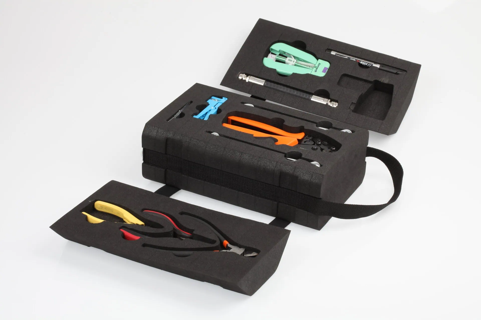 An open, hard-foam tool case containing various specialized tools for fibre optic assembly and termination, including orange crimping pliers, arranged neatly within custom-cut foam inserts.